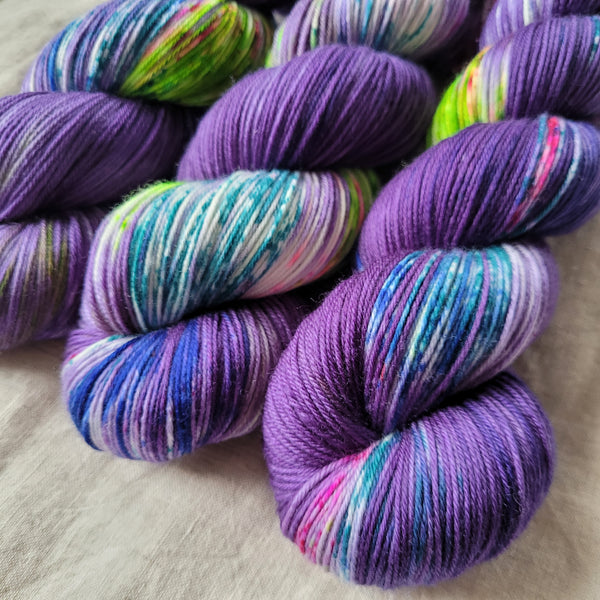 Skeins of hand dyed yarn in purple, blue and green tones