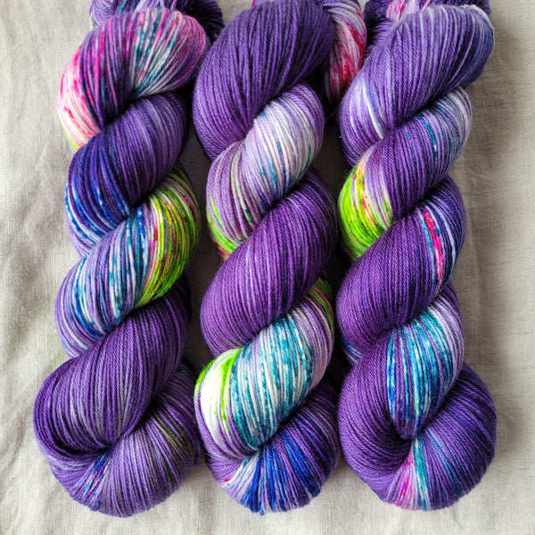 Skeins of hand dyed yarn in purple, blue and green tones